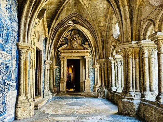 Gewölbter Steinkreuzgang mit blauen und weißen Azulejo-Kacheln in der Kathedrale von Porto
