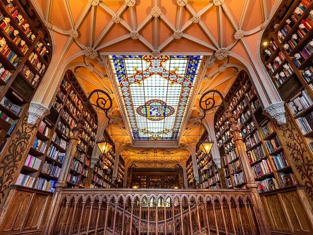 Das atemberaubende Innere der Livraria Lello mit hohen Bücherregalen und einer Buntglasdecke