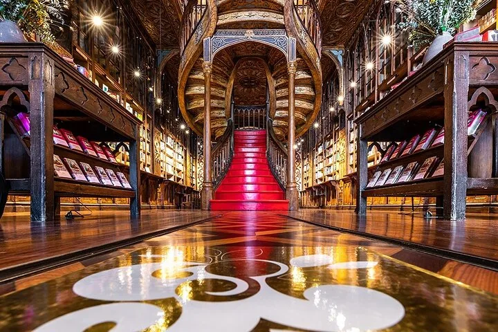 La famosa scala rossa e gli interni in legno decorato della Livraria Lello a Porto