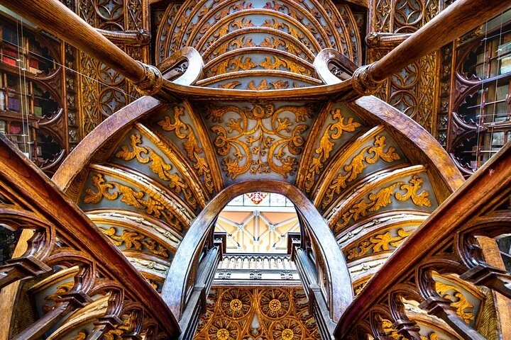 Nahaufnahme der aufwendig geschnitzten Holzbögen der Treppe in der Livraria Lello