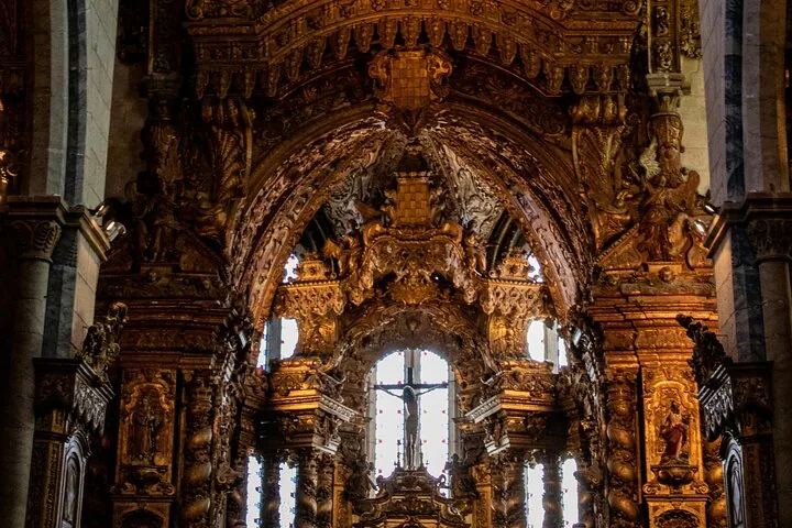 Dettagliati intagli in legno dorato e un crocifisso sopra un altare all'interno di una chiesa