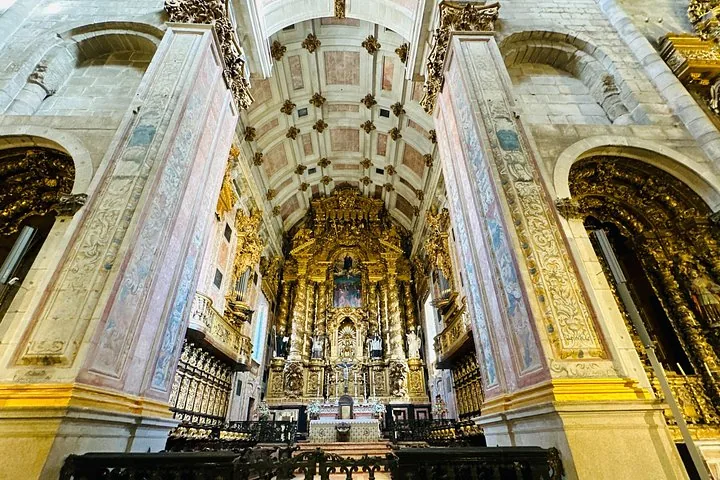 Vista interna della Cattedrale di Porto con un altare dorato decorato e un soffitto dipinto