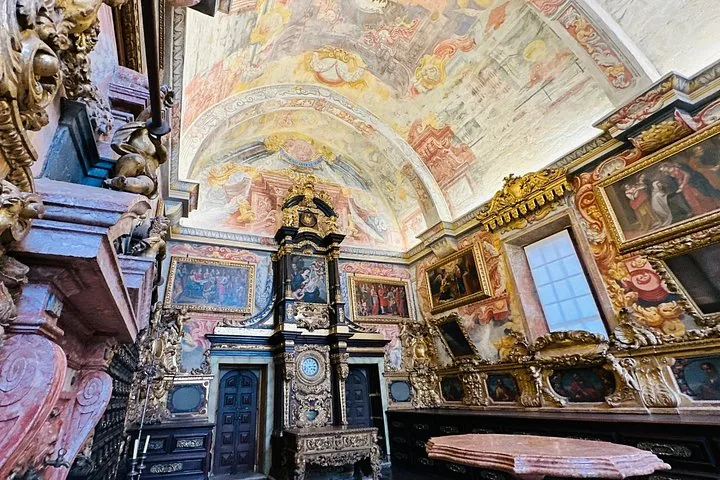 Een sierlijke ruimte in de Kathedraal van Porto met een beschilderd plafond en ingelijste kunstwerken