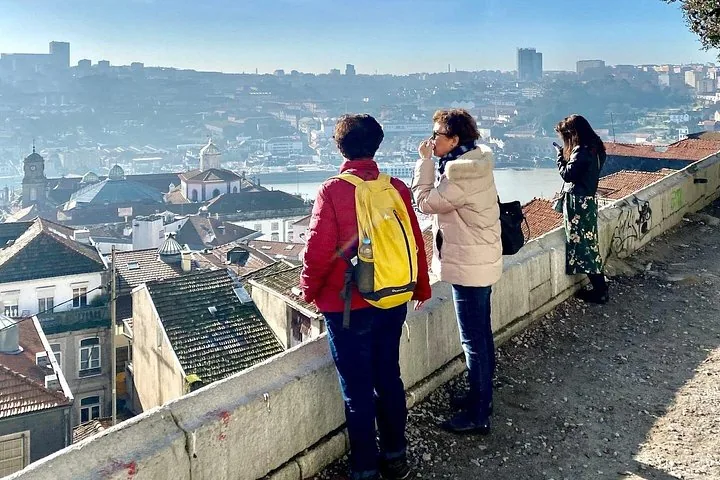 Turisti fermi a un punto panoramico che si affaccia sulla città storica di Porto